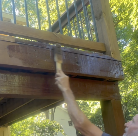 StainPaddle™ Wool Stain Applicator 14” being used overhead to reach upper deck.